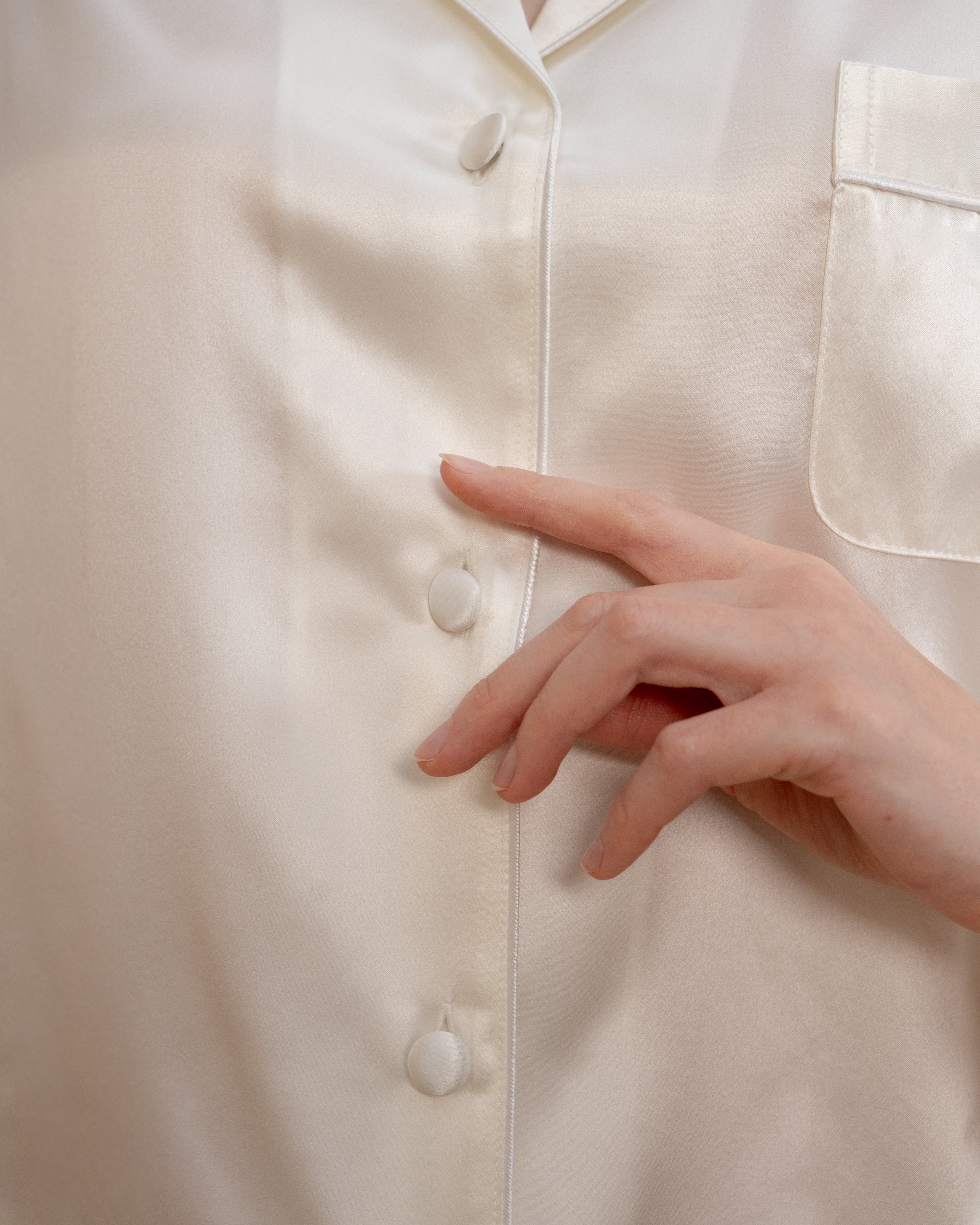 Close-up of the buttons on an Ivory NORA Silk pajama set, premium silk material for pajama sets.