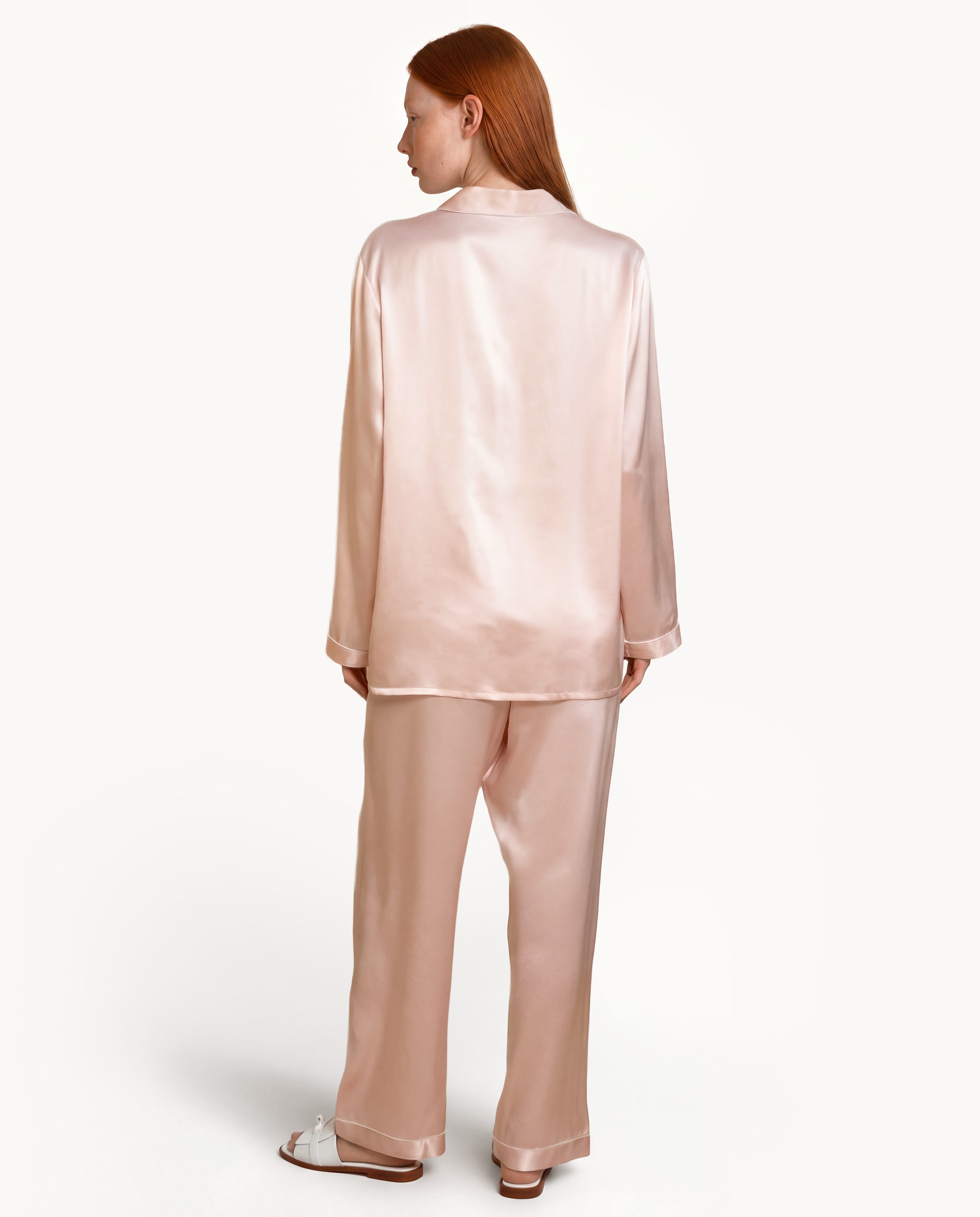 Back view of model in Light Pink silk pajamas, luxury silk material sleep in shirt and silk sleepwear gown style for womens pajamas and pink silk pajamas.